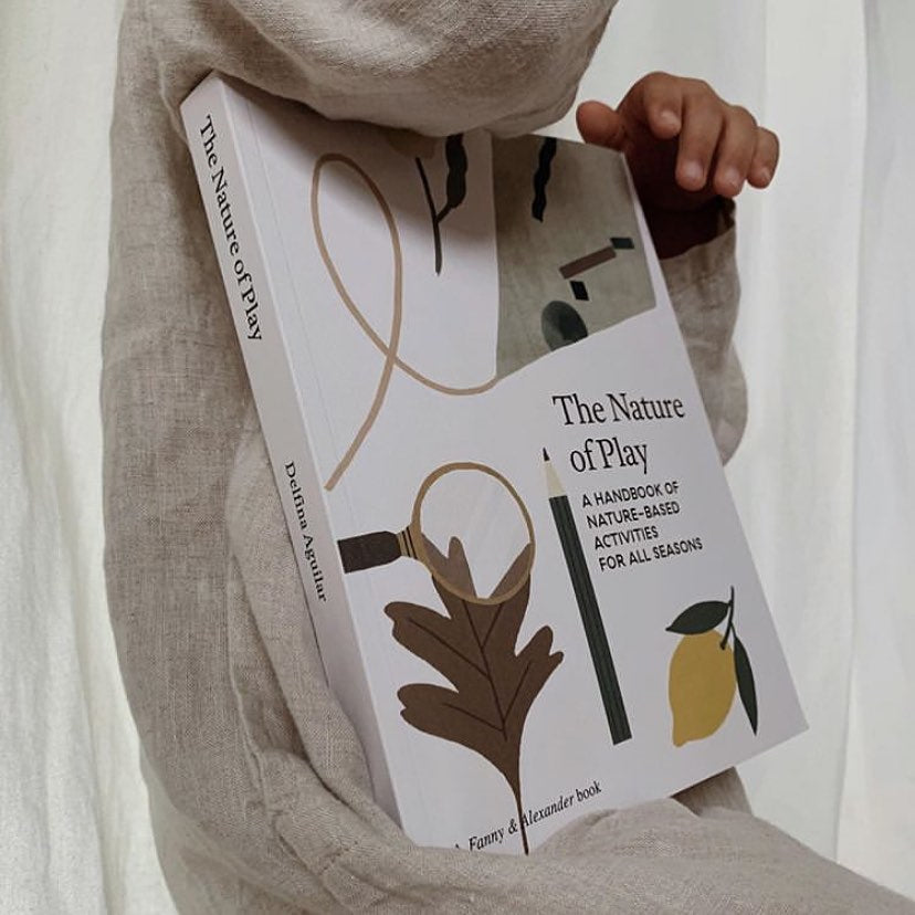 The Nature Of Play activity Book In The Hands Of A Child