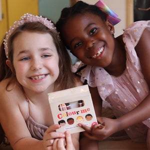 Two Children Holding a Pack of Colour Me Kids Skin Tone Crayons 